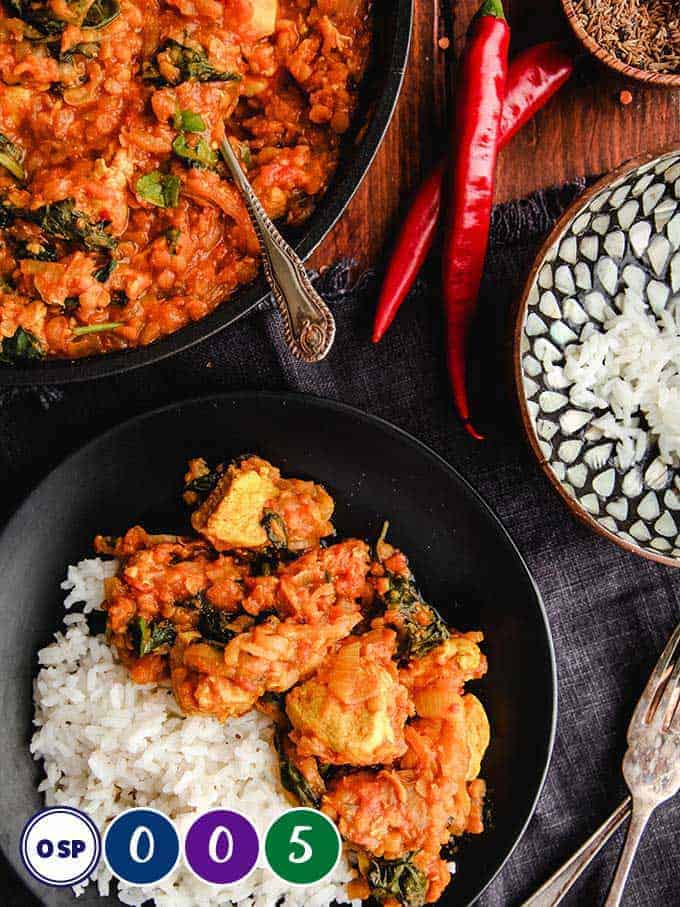 A tabletop full of dishes of curry and rice