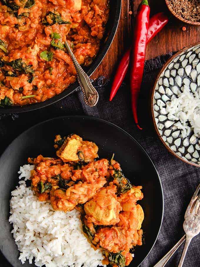 Zero point curry on a black plate with rice with red chilies.