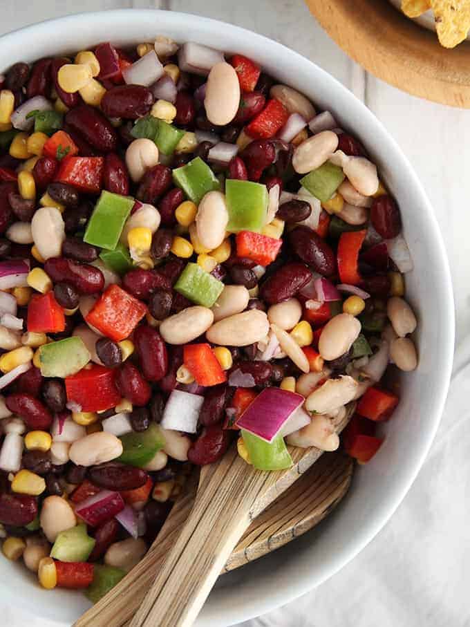 A close up of mexican bean salad in a white china bowl