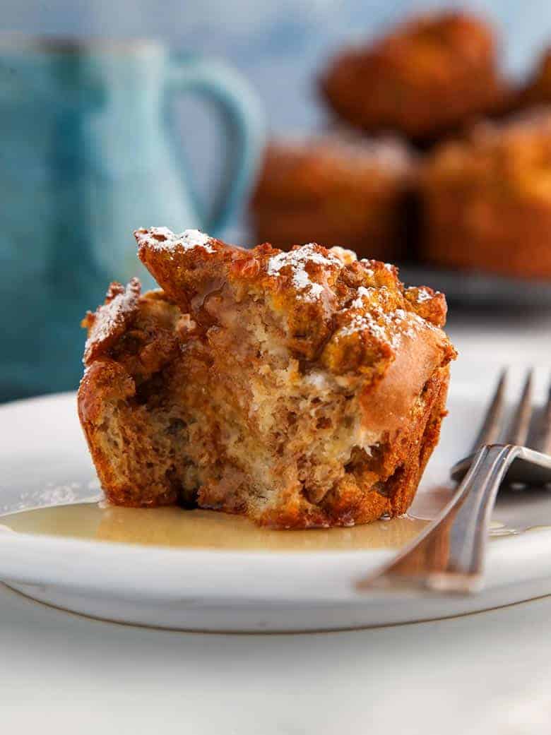 A pumpkin spiced french toast muffin with a fork on a white plate