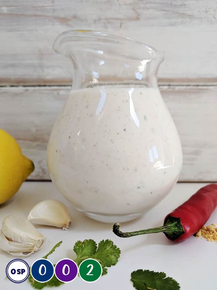 A glass jug full of salad dressing and list of SmartPoint values