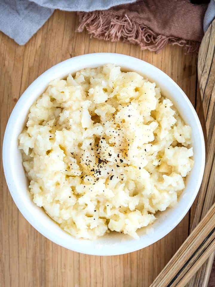 A bowl of celeriac mash on a wooden table