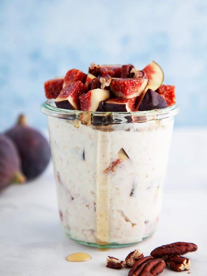 A jar of overnight oats topped with figs and bits of pecans