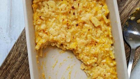 A dish of mac & cheese on a wooden board
