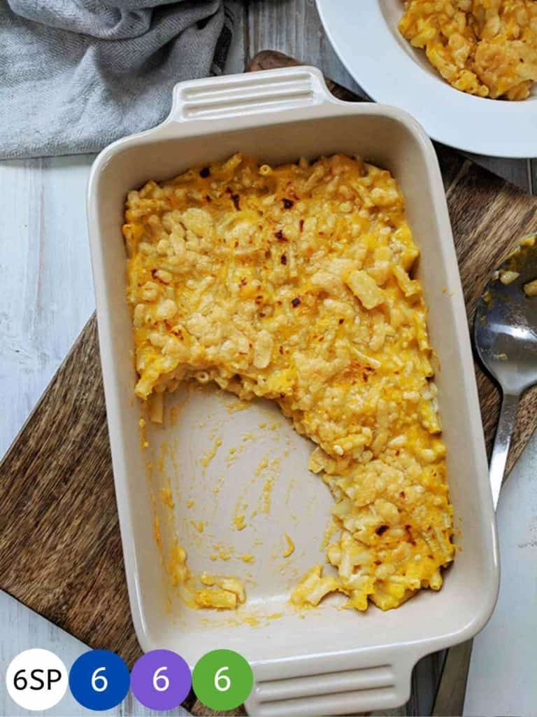 A dish of mac & cheese on a wooden board