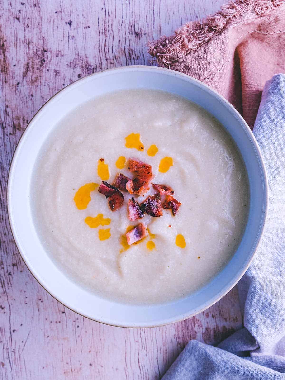 A bowl of white bean soup on a wooden table