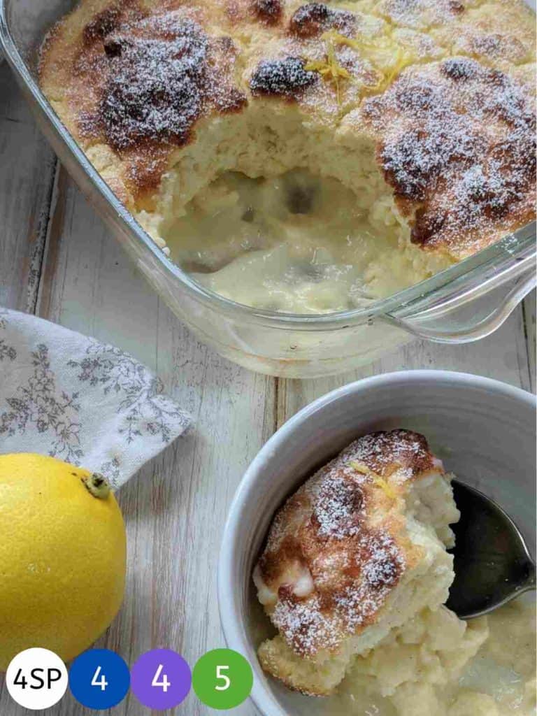 A glass dish of Lemon Pudding on a wooden table