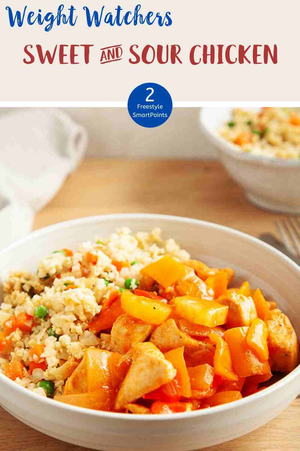 A white bowl of sweet & sour chicken with cauliflower rice on a wooden table