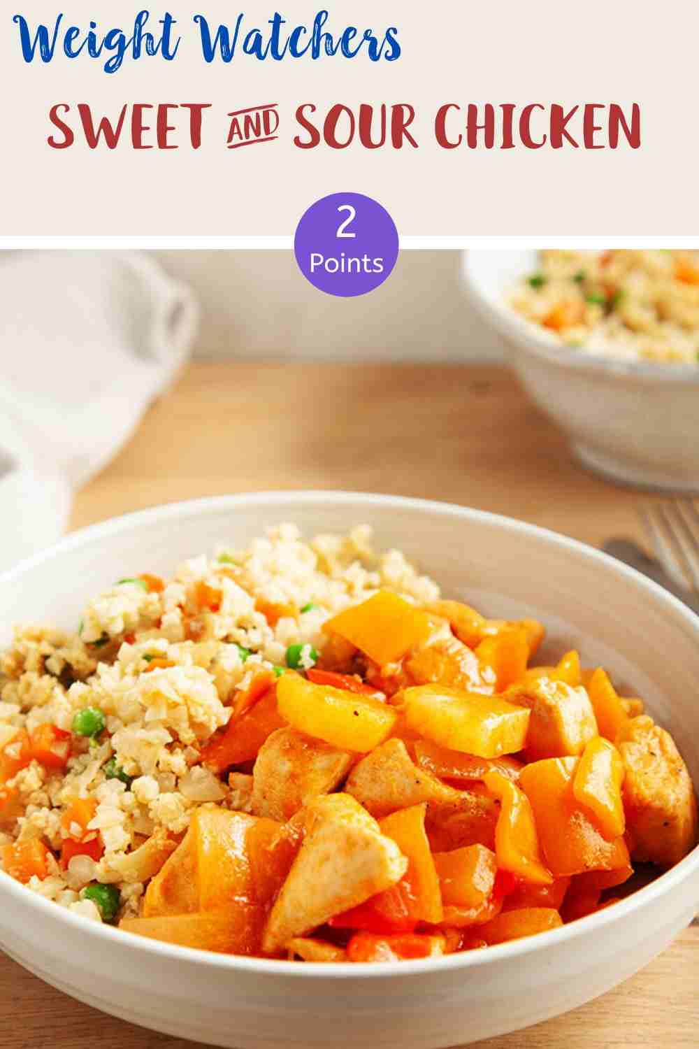 A white bowl of sweet & sour chicken with cauliflower rice on a wooden table