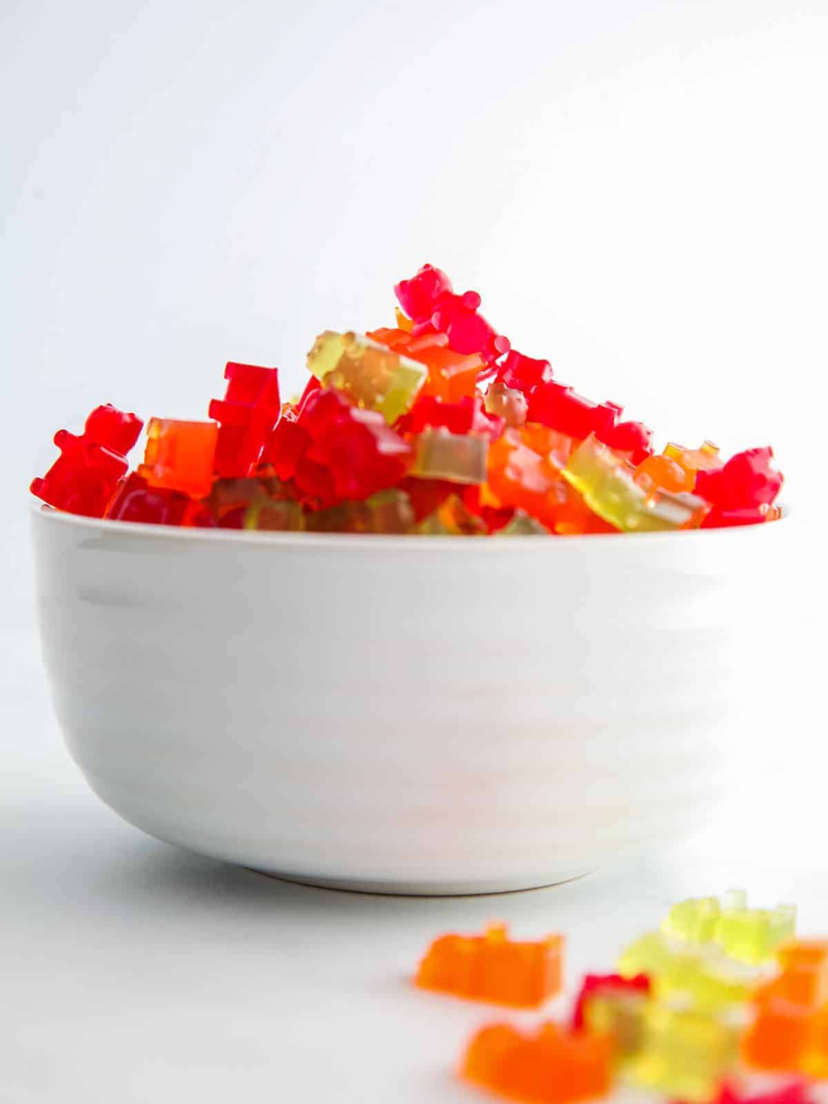 A white bowl of red, green and orange gummy bears