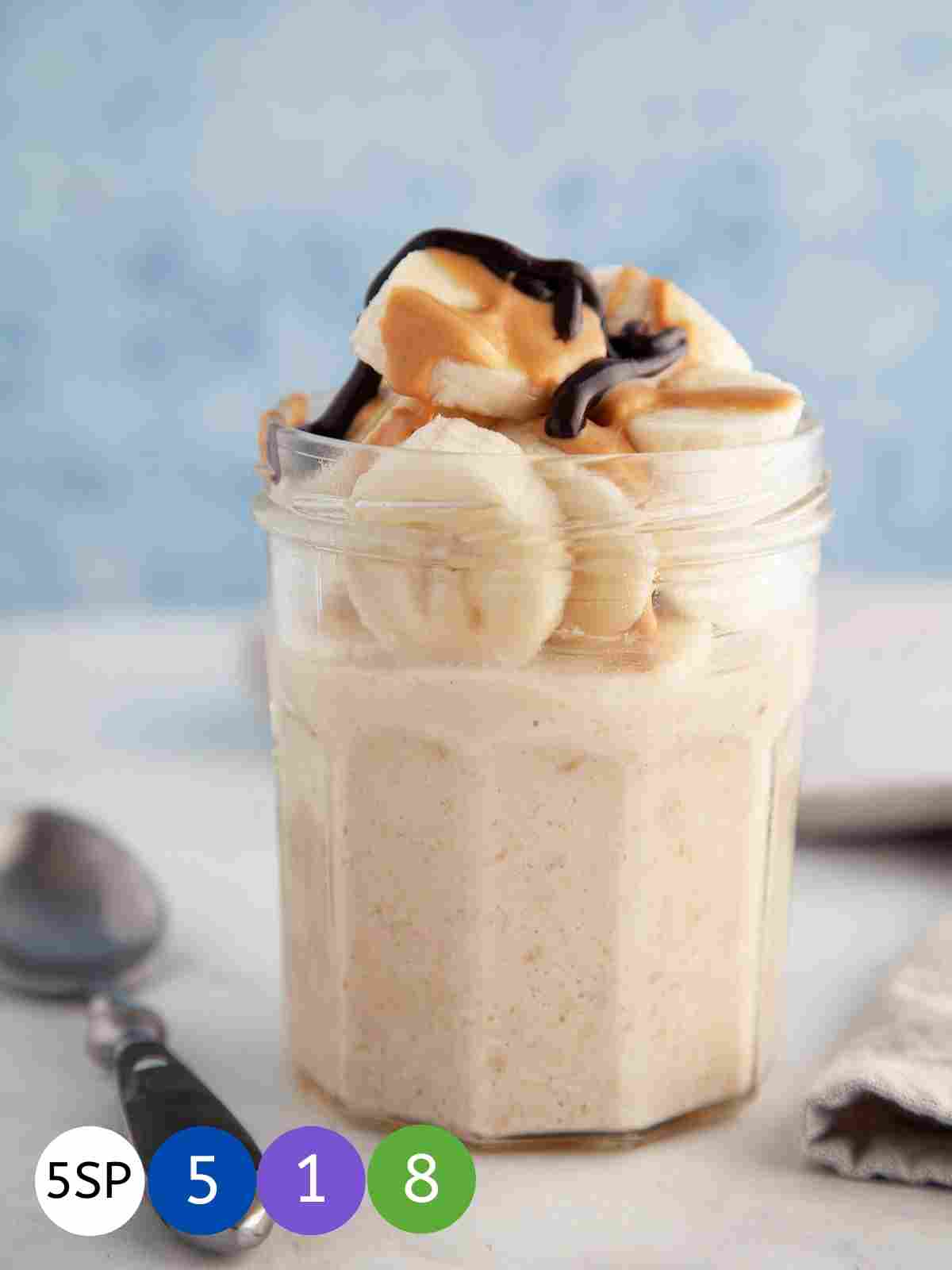 A jar full of overnight oats topped with banana