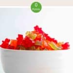A white bowl of red, green and orange gummy bears