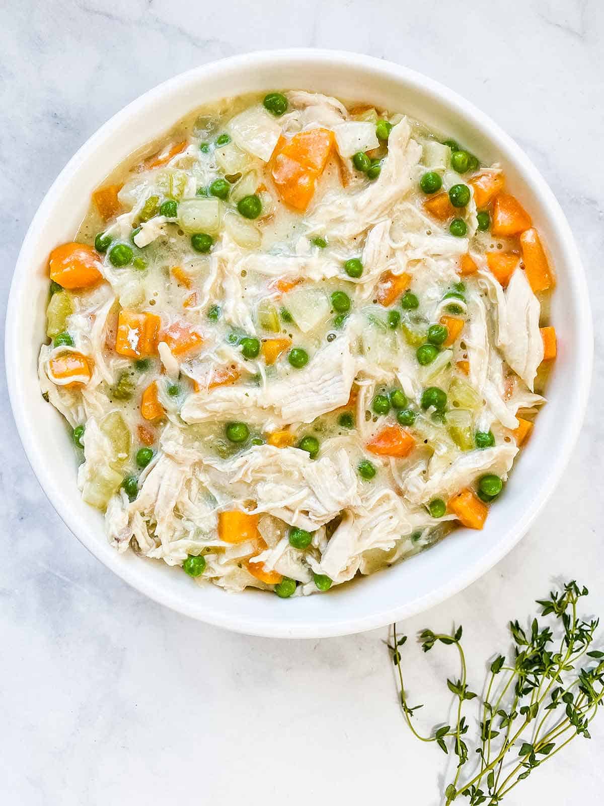 Chicken and vegetable pie filling in a white bowl