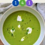 A white bowl full of bright green pea soup.