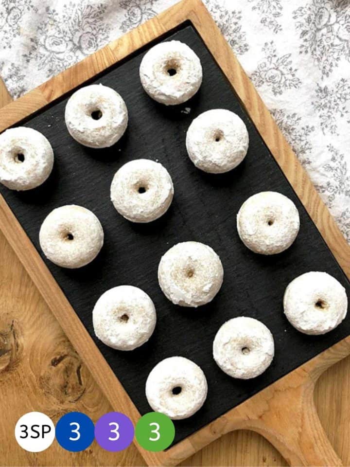 A tray of mini doughnuts on a wooden table.