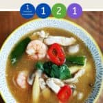 A bowl of tom yum soup on a wooden table with text overlay stating 'Weight Watchers Tom Yum Soup'.