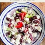 A bowl of greek salad on a wooden table with title text overlay and SmartPoint values.