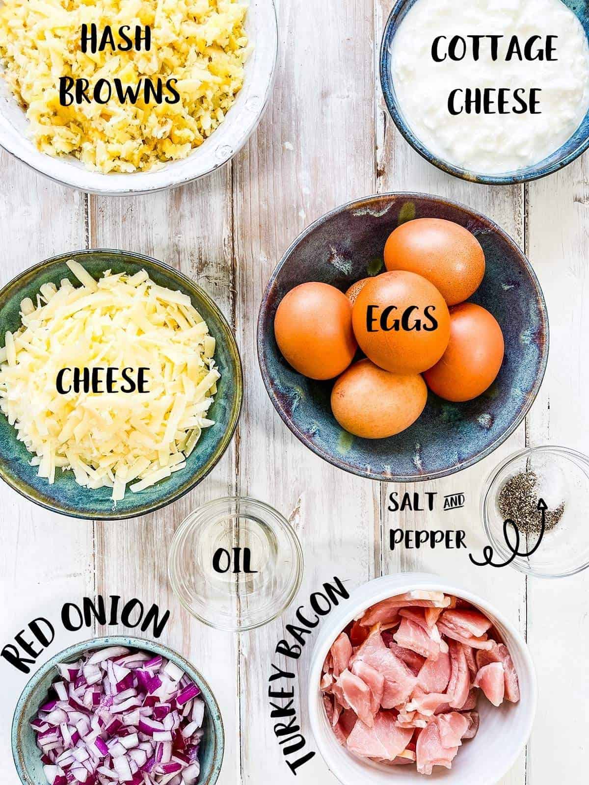 Bowls of the ingredients to make a breakfast casserole on a white table with text overlay labels.