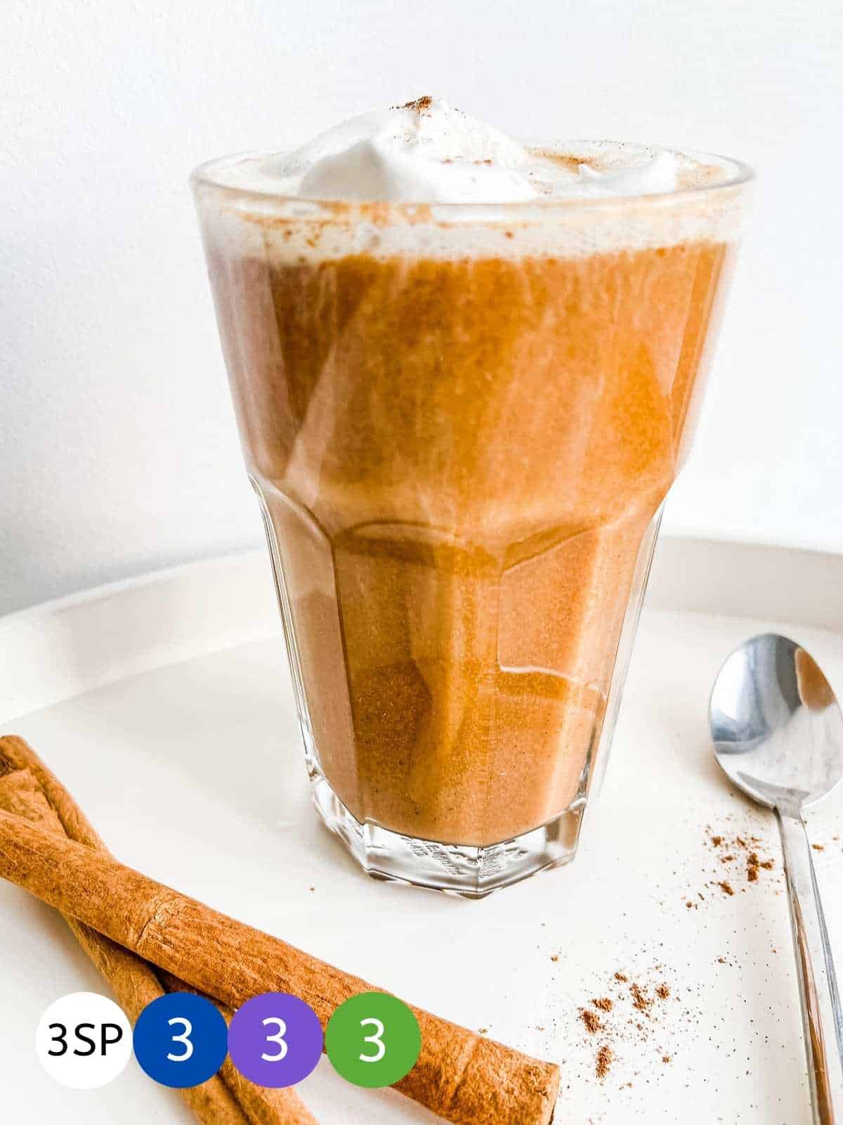 A glass of Pumpkin Spice Latte on a white table with SmartPoint values in coloured counters.