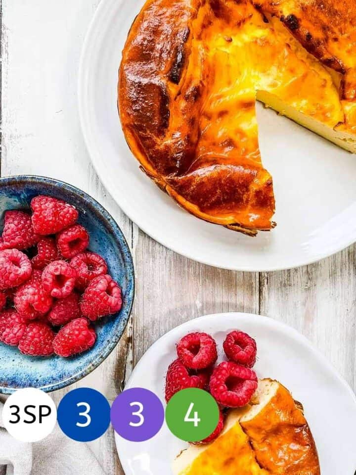 A yogurt tart on a white table with a bowl of raspberries and counter showing the SmartPoint value per slice on the Weight Watchers progam.