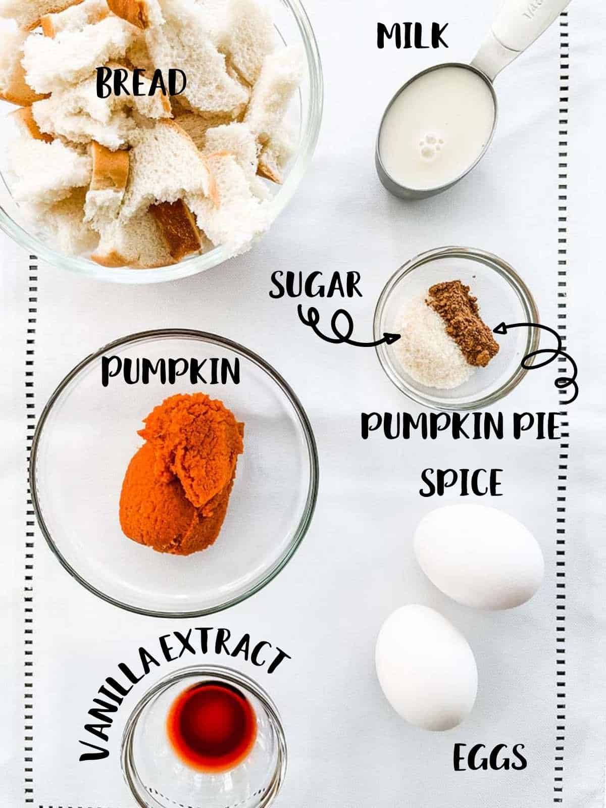 Ingredients needed to make Pumpkin Spice French Toast Casserole laid out on a white table.