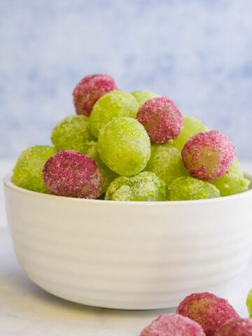 A bowl of red and green jello grapes.