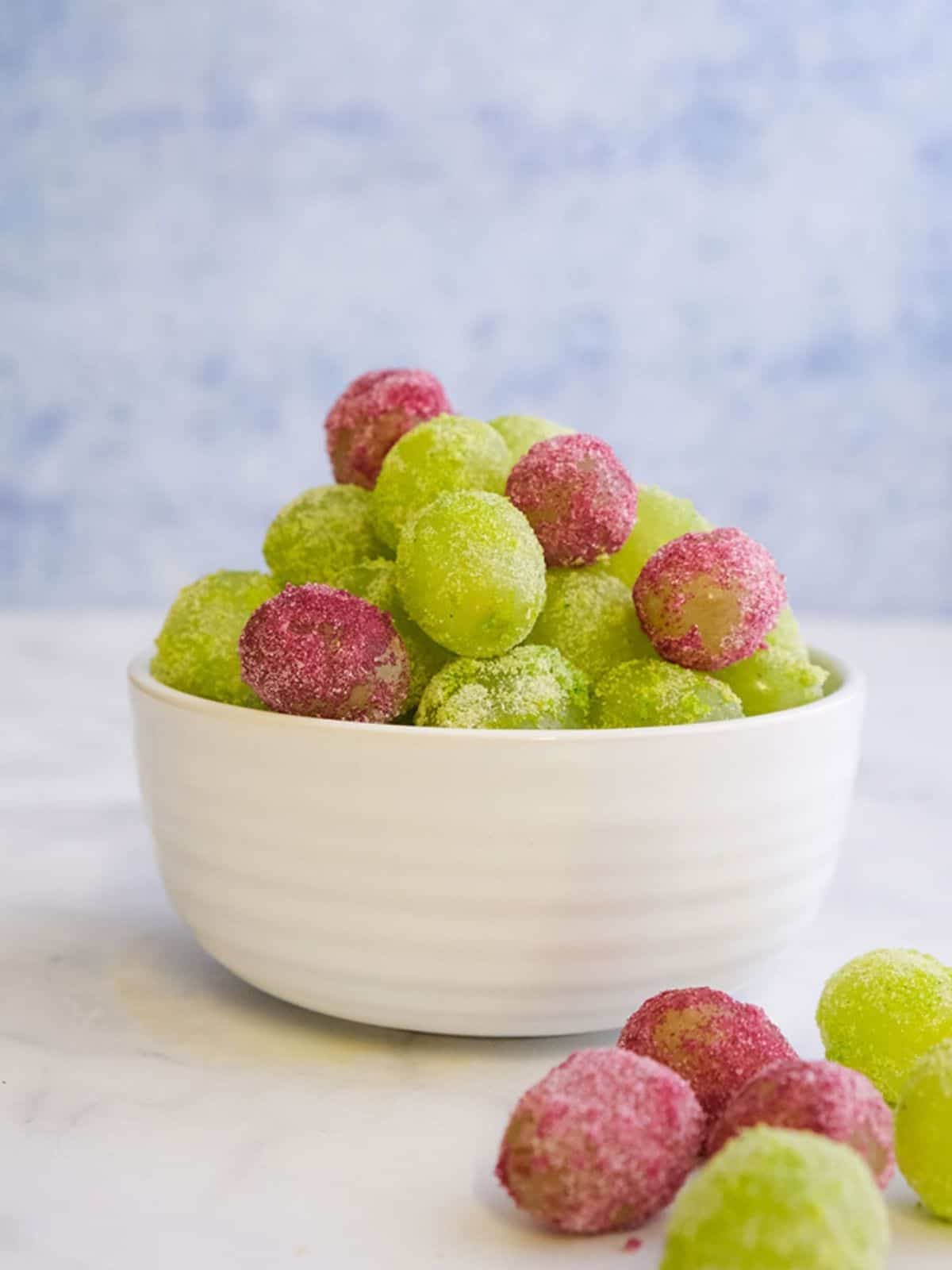 Red & Green Jello Grapes in a white bowl.