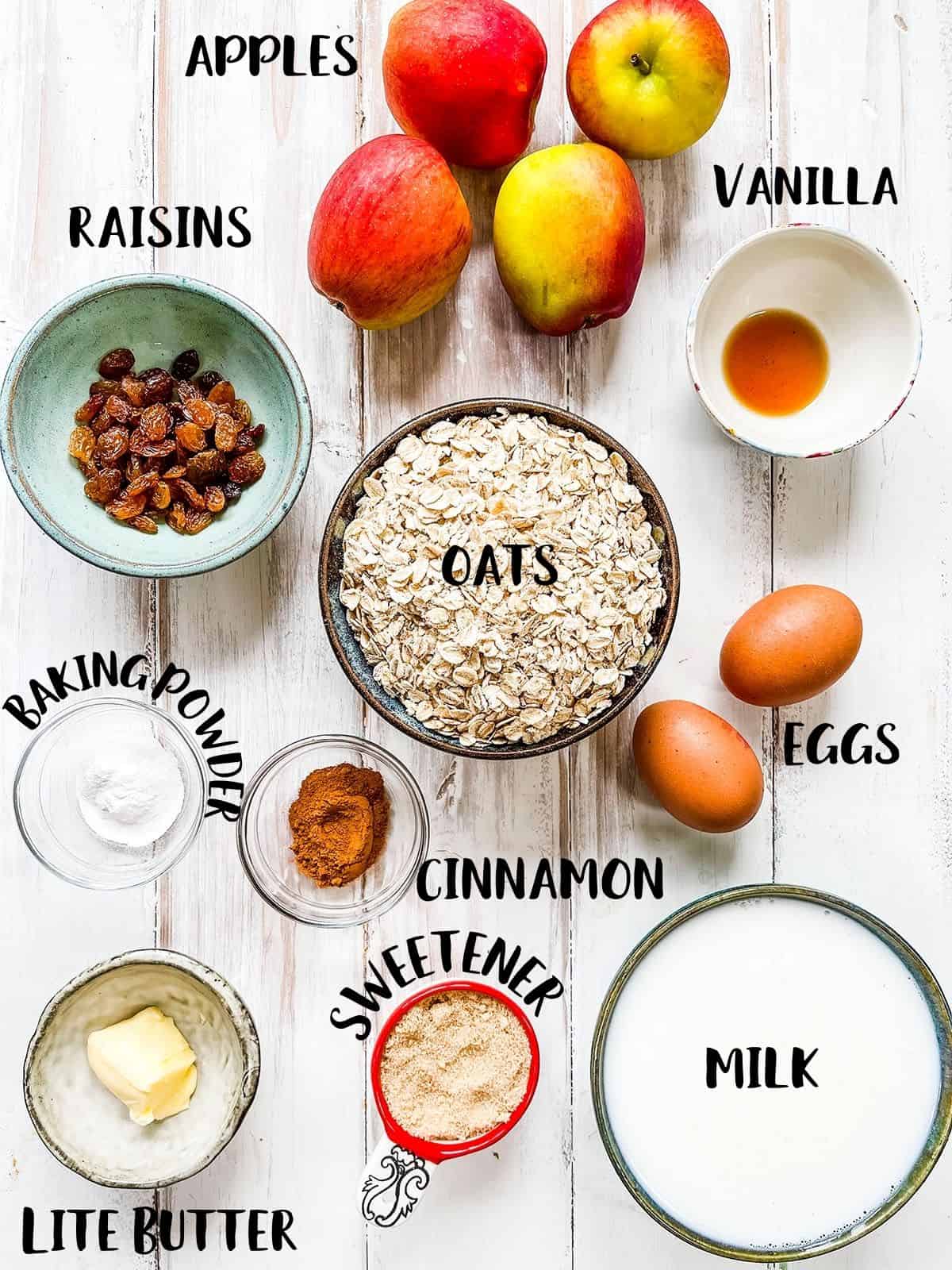 The ingredients to make baked oatmeal with apples laid out on a white table.