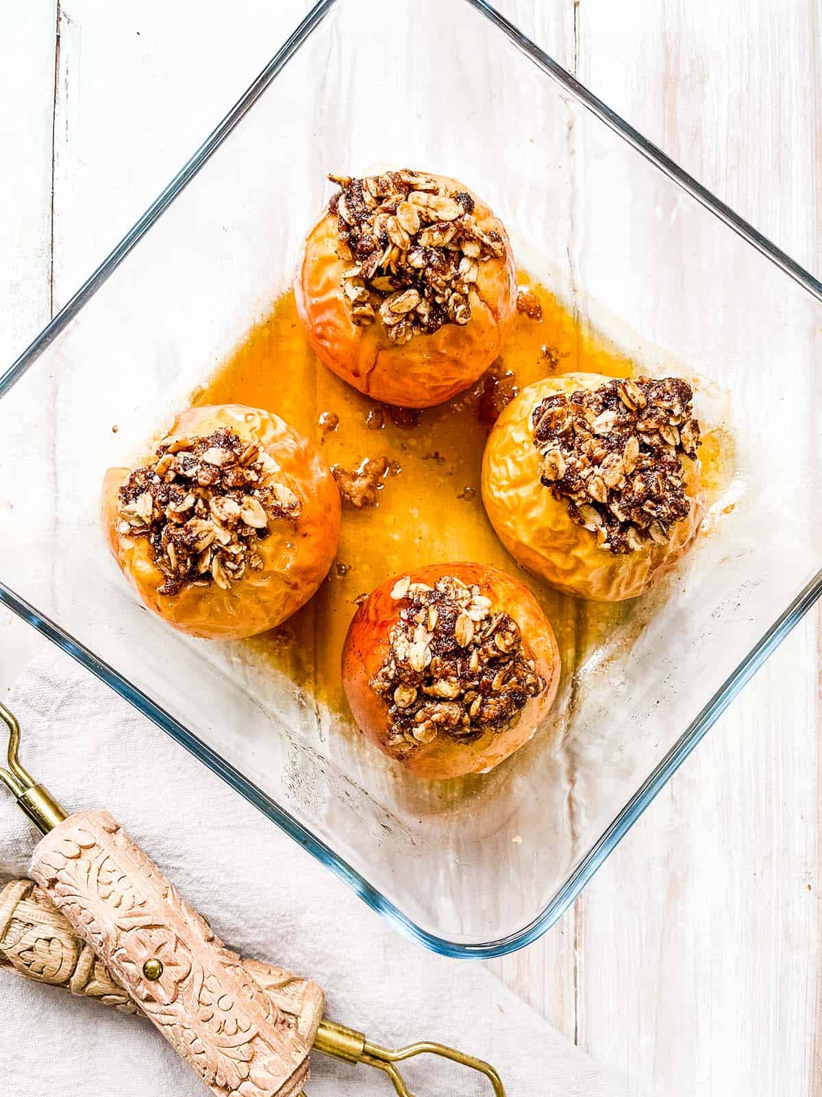 A glass dish with 4 baked apples.