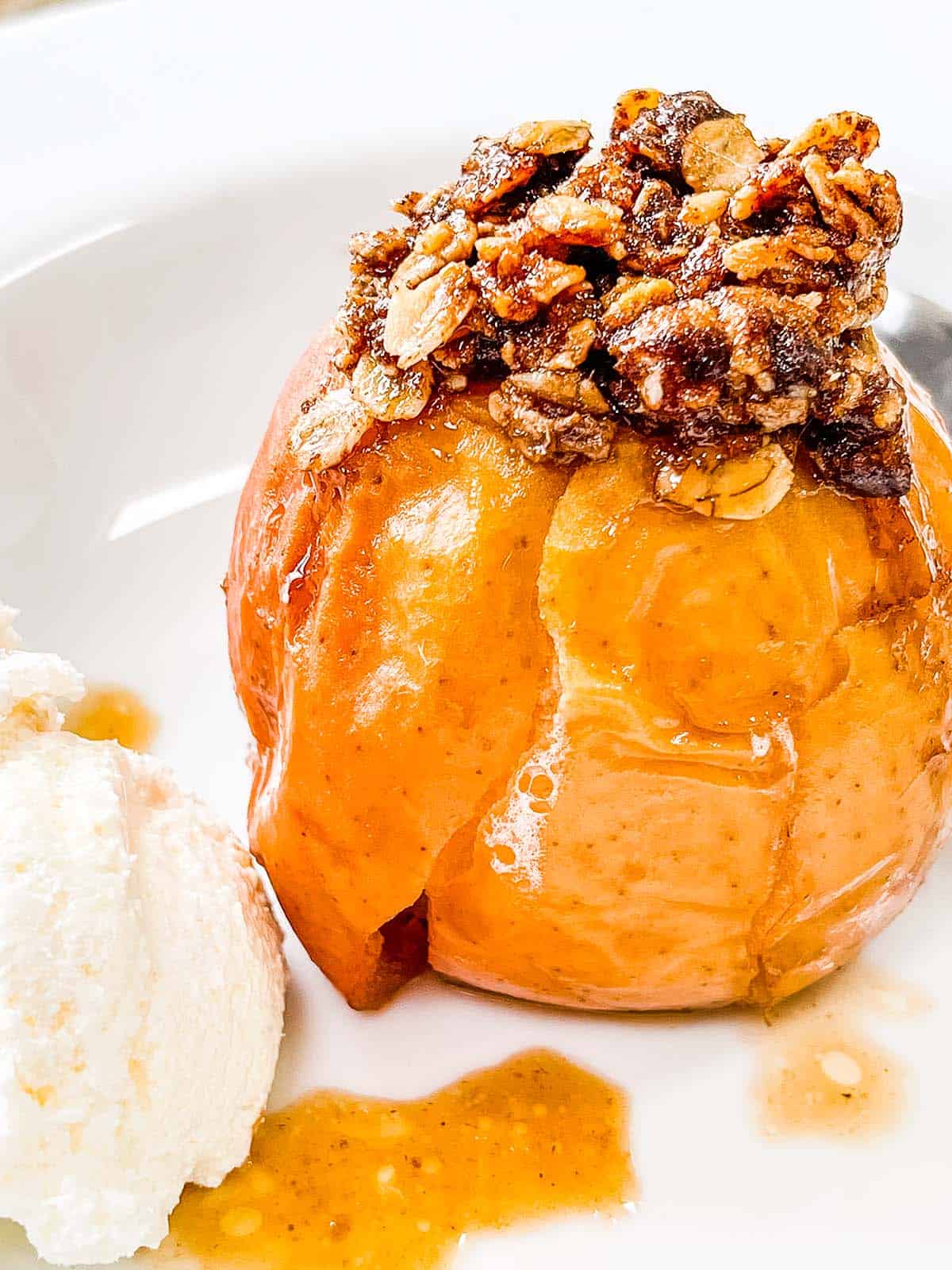 A baked apple with a side of ice cream.
