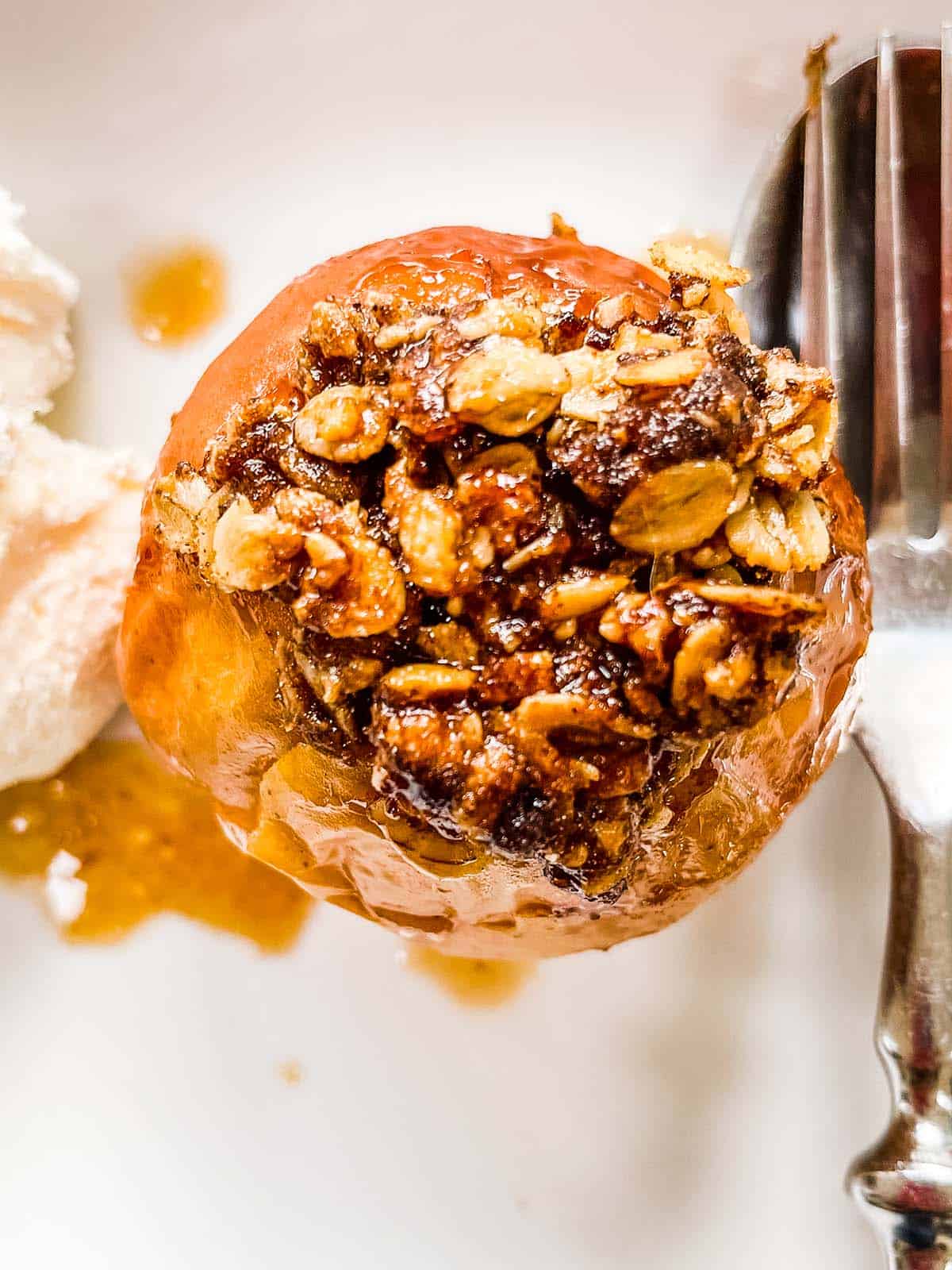 A top down picture of a baked apple in a white dish.