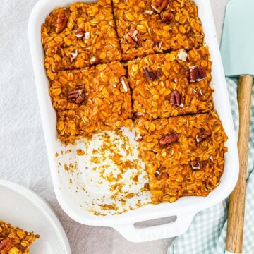 A white ceramic dish full of baked oats on a linen tablecloth.