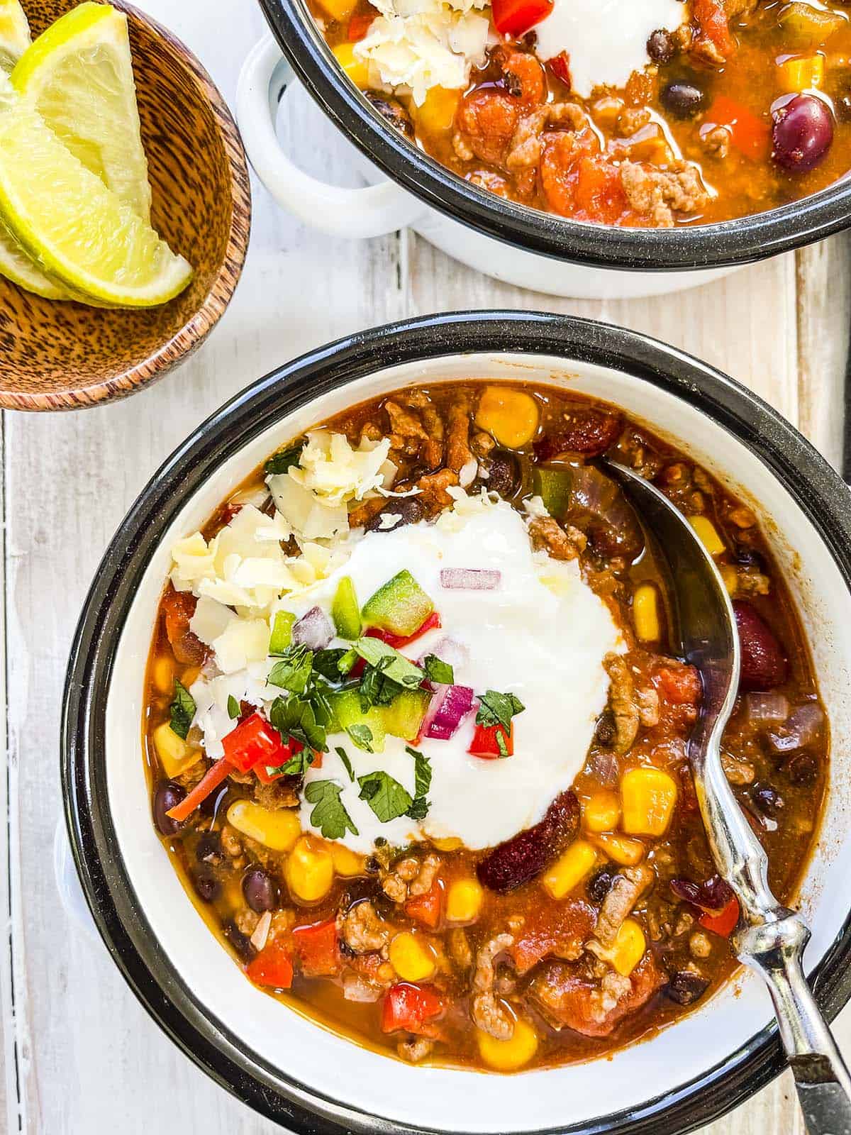 Taco soup in two bowls on a white table.