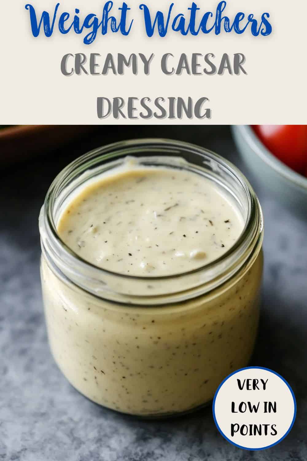 A jar of dressing on a grey table top with text overlay stating Weight Watchers Creamy Caesar Dressing - very low in points.