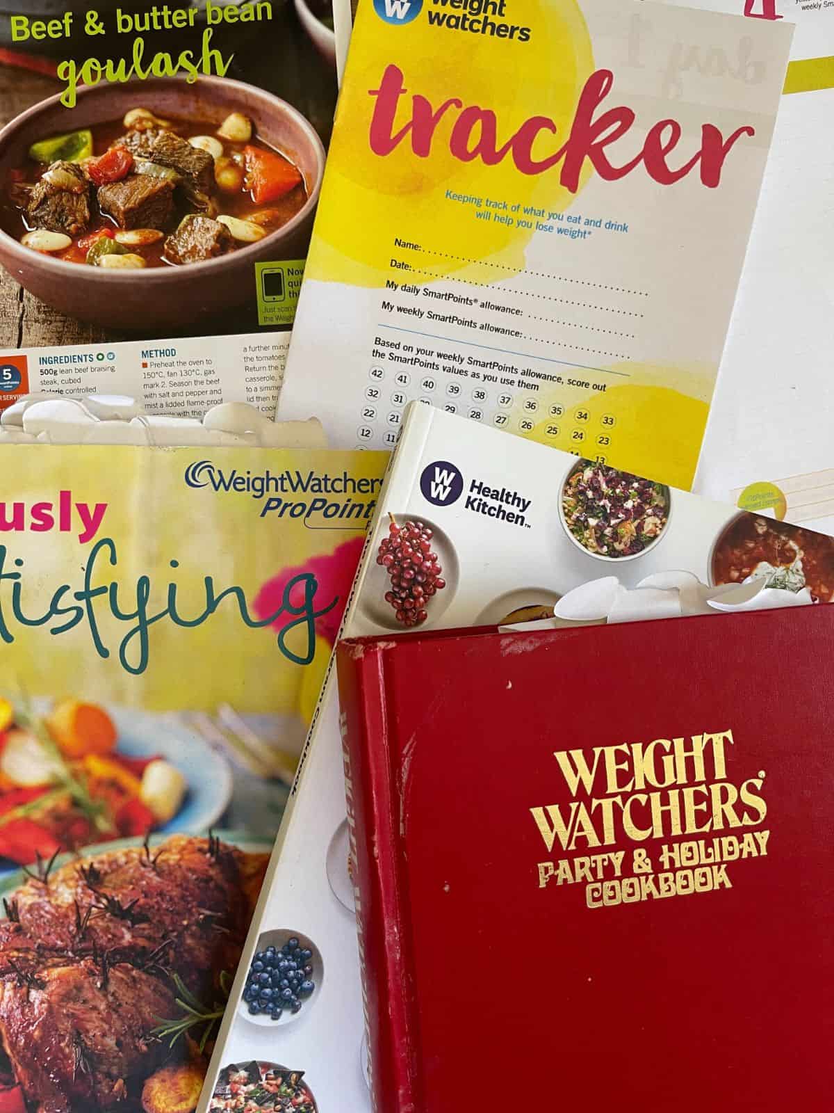 A photograph of a collection of old Weight Watchers leaflets and cook books as a flatlay.